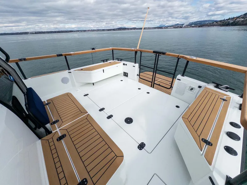 Slide: The Image of 2024 Targa 37 boat deck with wooden seating, overlooking calm waters and distant mountains. - 23
