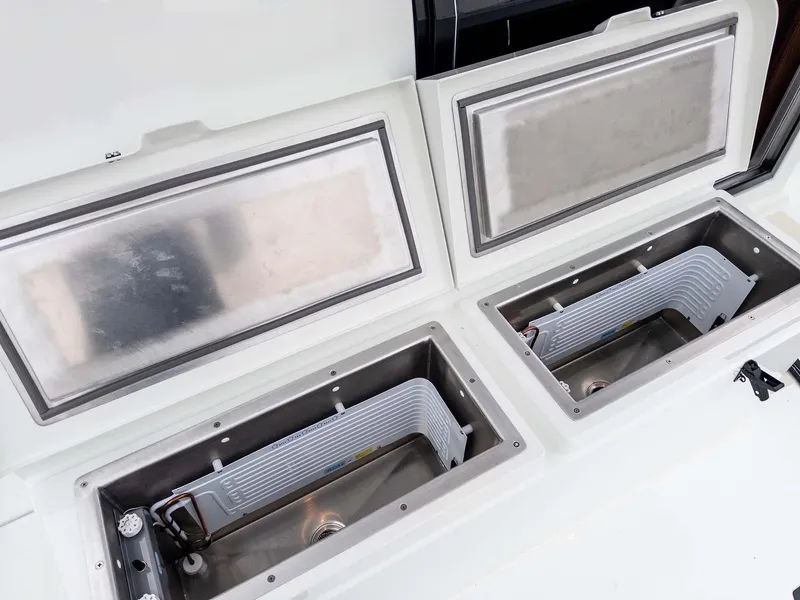 Slide: The Image of 2024 Targa 37 boat storage compartments with open lids, showcasing interior design. - 25