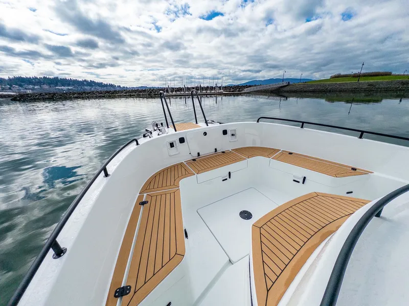 Slide: The Image of 2024 Targa 37 boat with wooden deck, docked in a scenic marina under cloudy skies. - 30