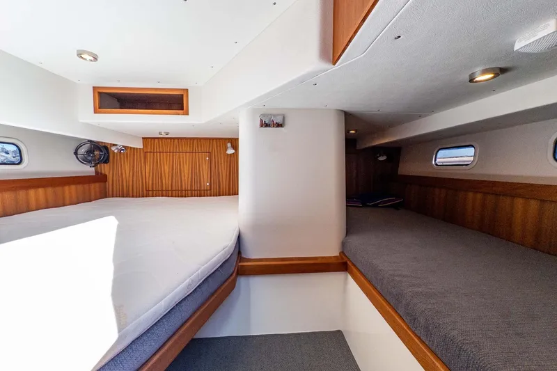 Slide: The Image of 2024 Targa 37 yacht interior cabin with wooden accents and comfortable bedding. - 33