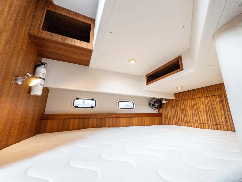 Slide: The Image of 2024 Targa 37 cabin interior with wood accents and cozy bedding. - 36