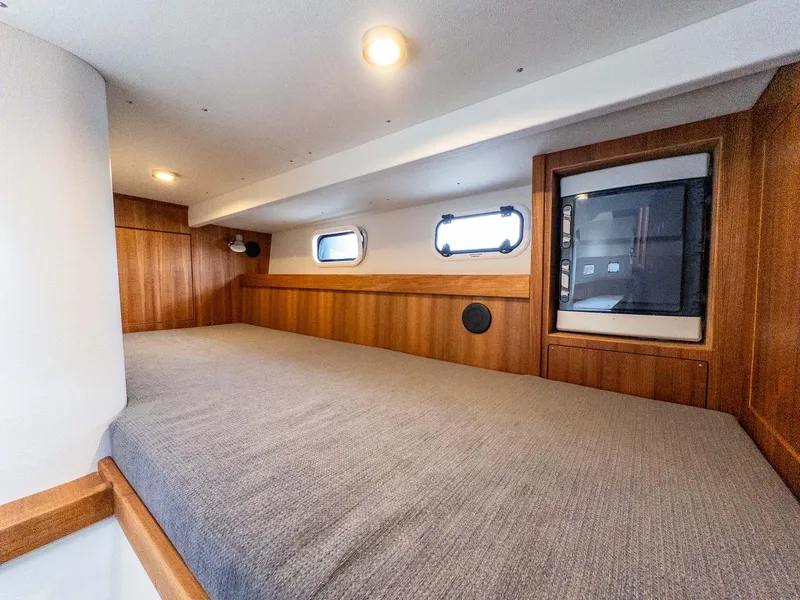 Slide: The Image of 2024 Targa 37 cabin interior with wooden finish and cozy bedding. - 37