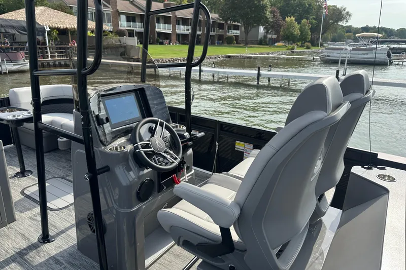 Slide: The Image of 2026 Qwest M-Class 24 Pro Sport boat interior with steering console and seating. - 6