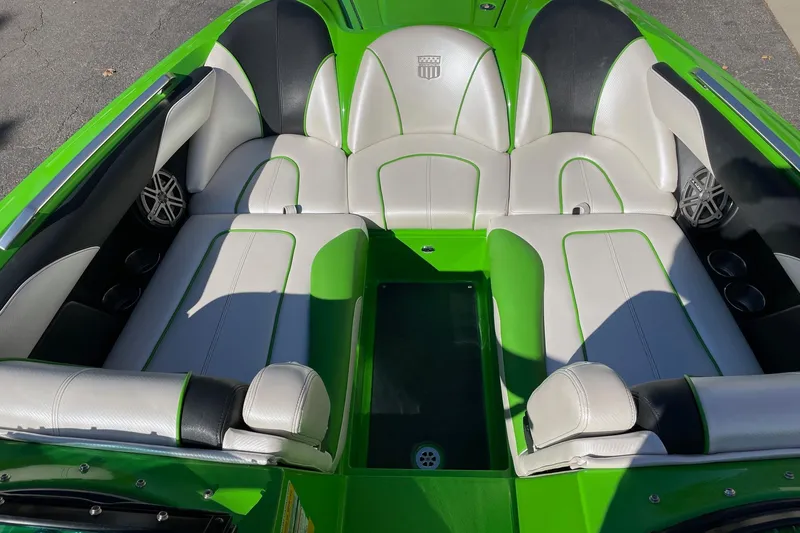 Slide: The Image of 2013 MasterCraft XStar boat interior with green and white seating, featuring premium speakers. - 11