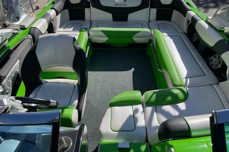Slide: The Image of 2013 MasterCraft XStar boat interior with green and white seating arrangement. - 12