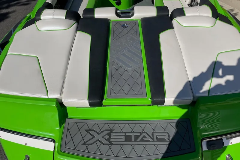 Slide: The Image of 2013 MasterCraft XStar boat with green and white seating, featuring "XStar" branding. - 4