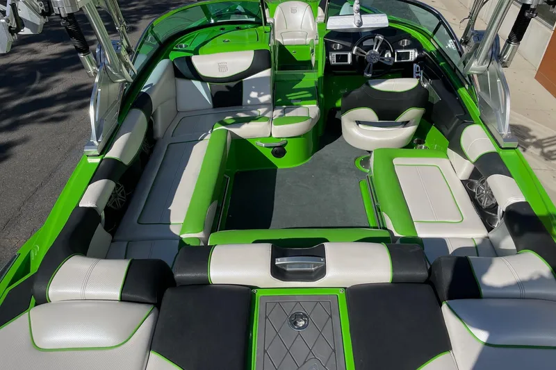 Slide: The Image of 2013 MasterCraft XStar boat interior with green and white seating, sleek design. - 5