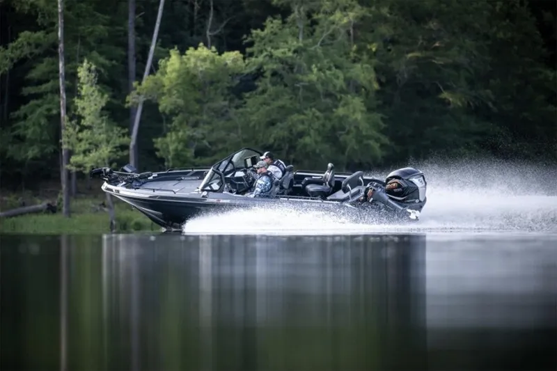 Slide: The Image of Manufacturer Provided Image: 2026 Skeeter WXR2060 F boat speeding on a calm lake with lush forest backdrop. - 25