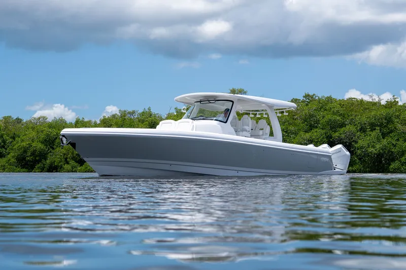 Slide: The Image of 2026 Intrepid 43 Nomad SE on calm water with green backdrop. - 2