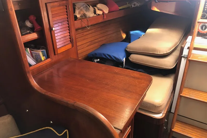 Slide: The Image of 1979 Cape Dory 36 interior with wooden table, cushions, and storage area. - 14
