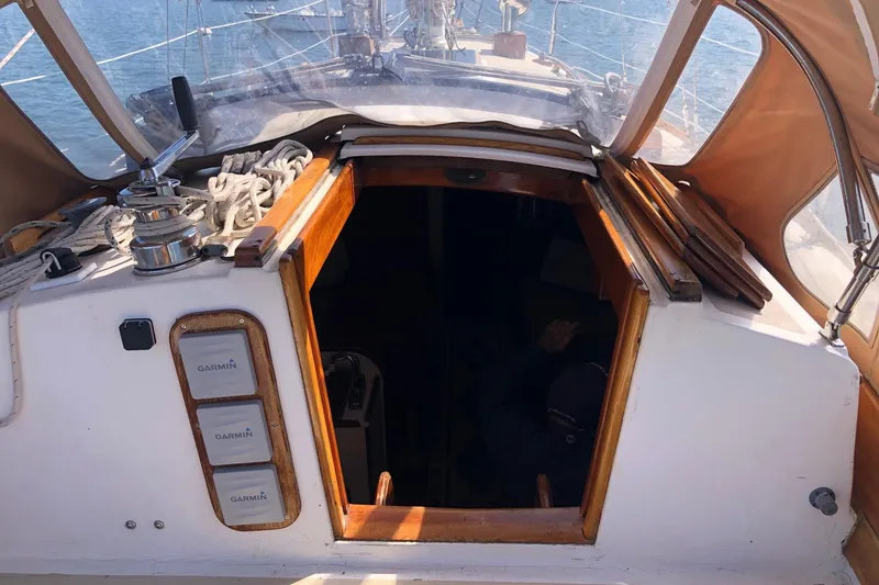 Slide: The Image of 1979 Cape Dory 36 sailboat cockpit with Garmin equipment and open cabin entrance. - 17