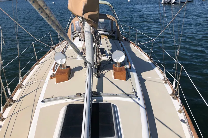 Slide: The Image of 1979 Cape Dory 36 sailboat deck view, featuring rigging and ocean backdrop. - 18