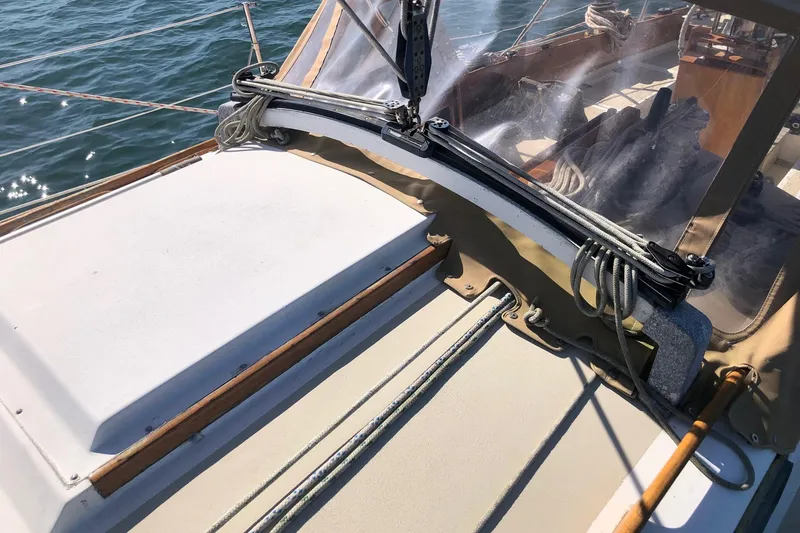 Slide: The Image of 1979 Cape Dory 36 sailboat deck with rigging and clear canopy on the water. - 23