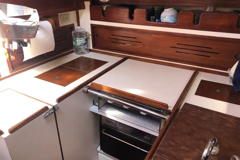 Slide: The Image of 1979 Cape Dory 36 yacht galley with wooden cabinetry and compact appliances. - 5