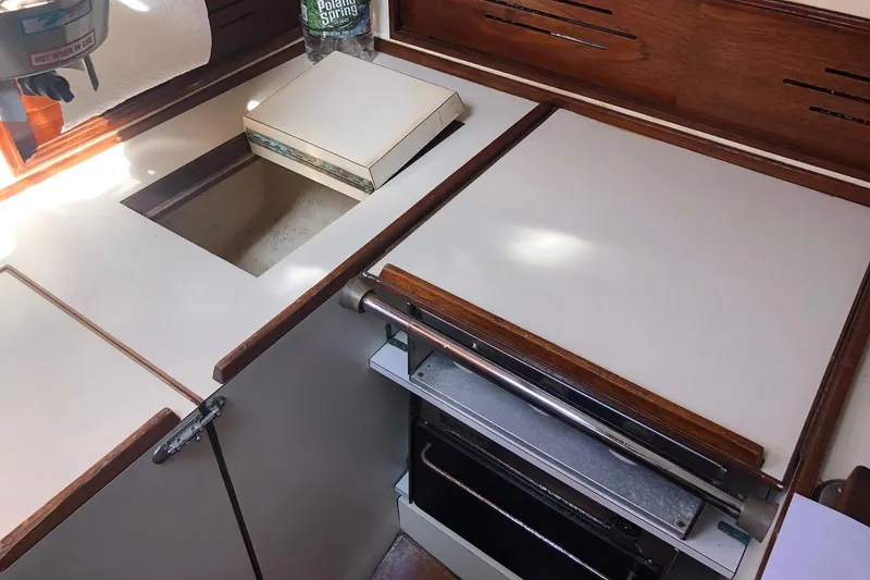 Slide: The Image of 1979 Cape Dory 36 yacht galley with wooden accents and built-in stove. - 6
