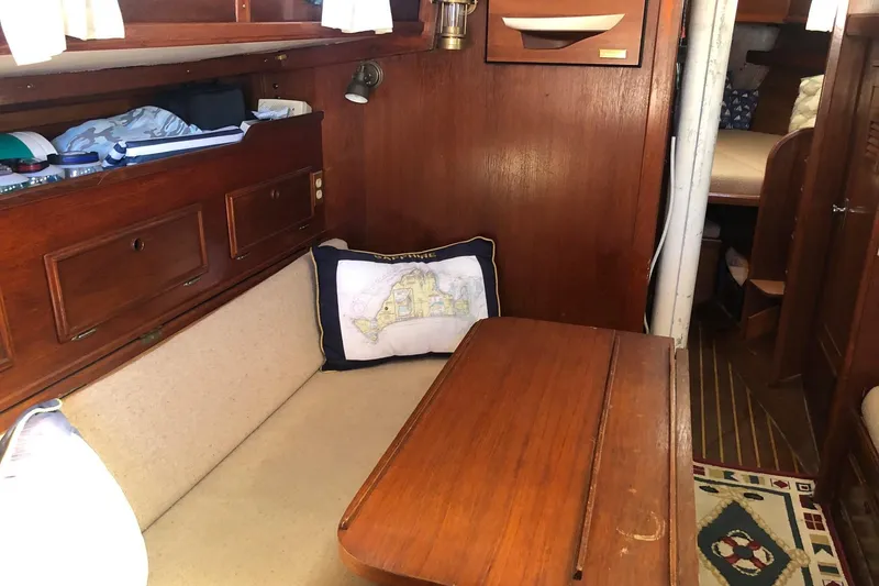 Slide: The Image of Cozy interior of 1979 Cape Dory 36 sailboat with wooden furnishings and nautical decor. - 8