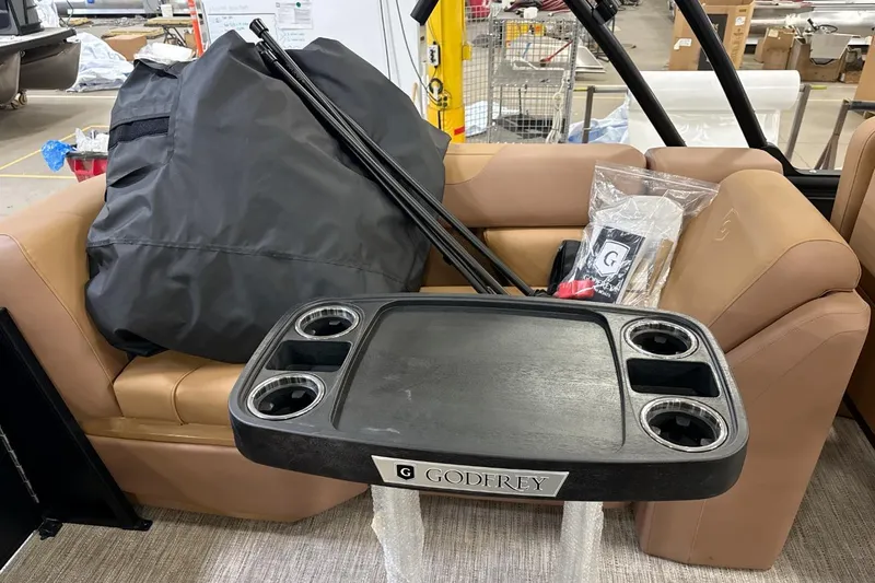 Slide: The Image of 2026 Godfrey Sweetwater 22' Tritoon interior with table and seating. - 10