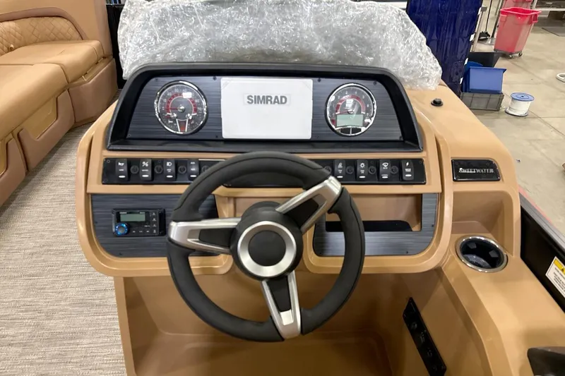 Slide: The Image of Steering console of 2026 Godfrey Sweetwater 22' Split Bench Tritoon, featuring modern controls and gauges. - 5