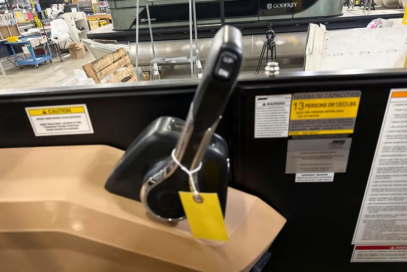 Slide: The Image of Control panel of 2026 Godfrey Sweetwater 22' Tritoon, showing capacity warnings and throttle lever. - 6