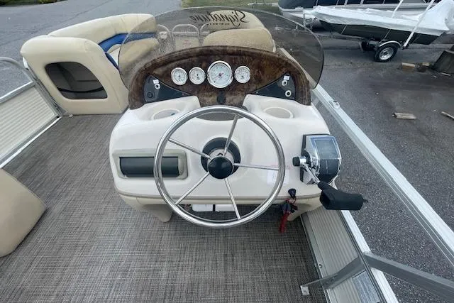 Slide: The Image of 2009 Sun Tracker Party Barge 21 boat dashboard with steering wheel and gauges. - 5