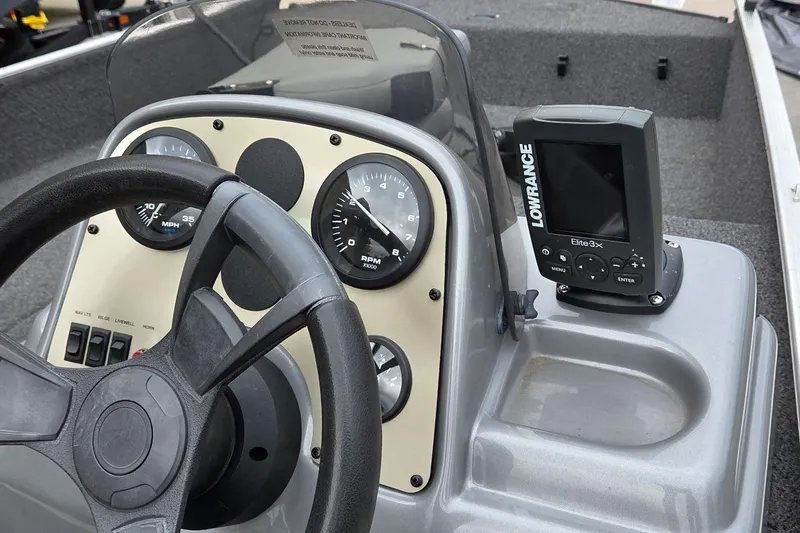 Slide: The Image of 2014 Lowe Stryker 17 boat dashboard with steering wheel and Lowrance Elite 3x fish finder. - 1