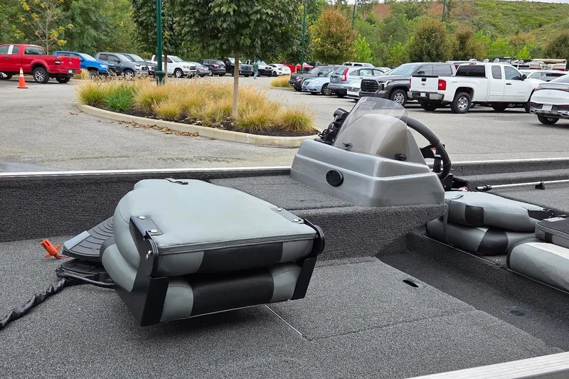 Slide: The Image of 2014 Lowe Stryker 17 boat interior with seating and steering console in a parking lot. - 5