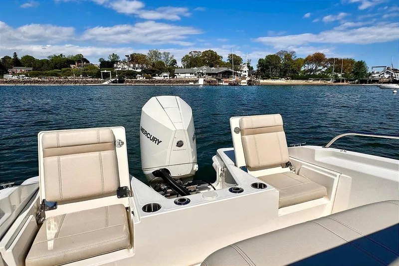 Slide: The Image of 2022 Boston Whaler 220 Dauntless boat with Mercury engine on calm water. - 4