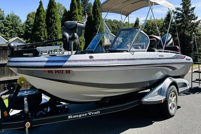 Slide: The Image of 2016 Ranger 190LS boat on trailer, featuring Minn Kota motor, parked outdoors. - 2