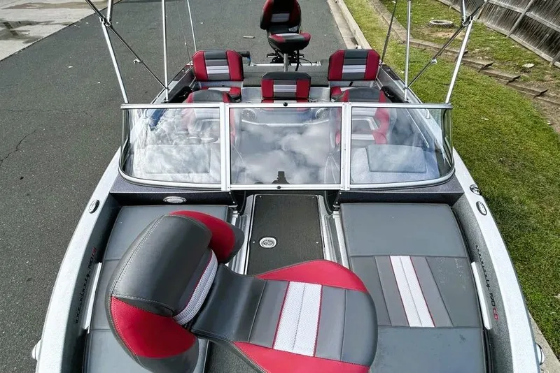 Slide: The Image of 2016 Ranger 190LS boat with red and gray seating, parked on a street. - 4