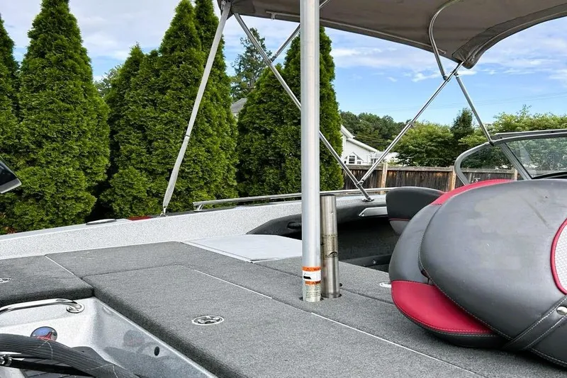 Slide: The Image of 2016 Ranger 190LS boat interior with seating and canopy, surrounded by lush greenery. - 5