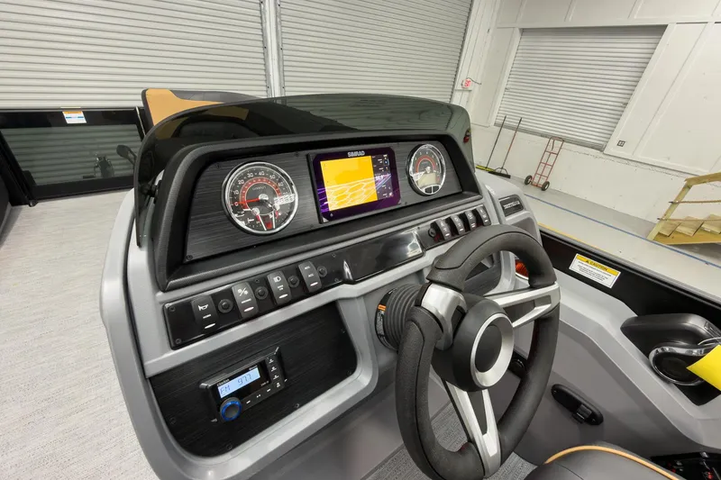 Slide: The Image of 2026 Godfrey Sweetwater 22' Tritoon dashboard with steering wheel and digital display. - 20
