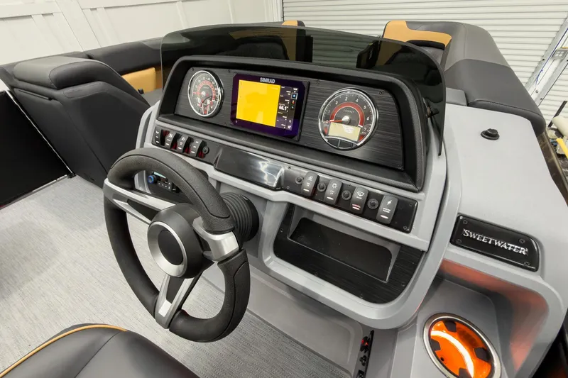 Slide: The Image of 2026 Godfrey Sweetwater 22' Tritoon dashboard with steering wheel and control panel. - 21