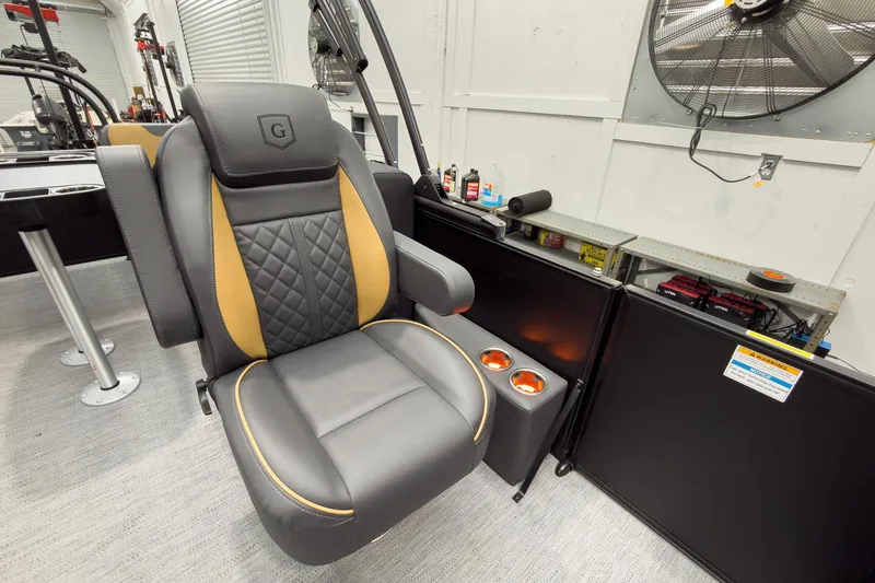 Slide: The Image of Luxurious captain's chair on 2026 Godfrey Sweetwater 22' Split Bench Tritoon, featuring cup holders. - 24