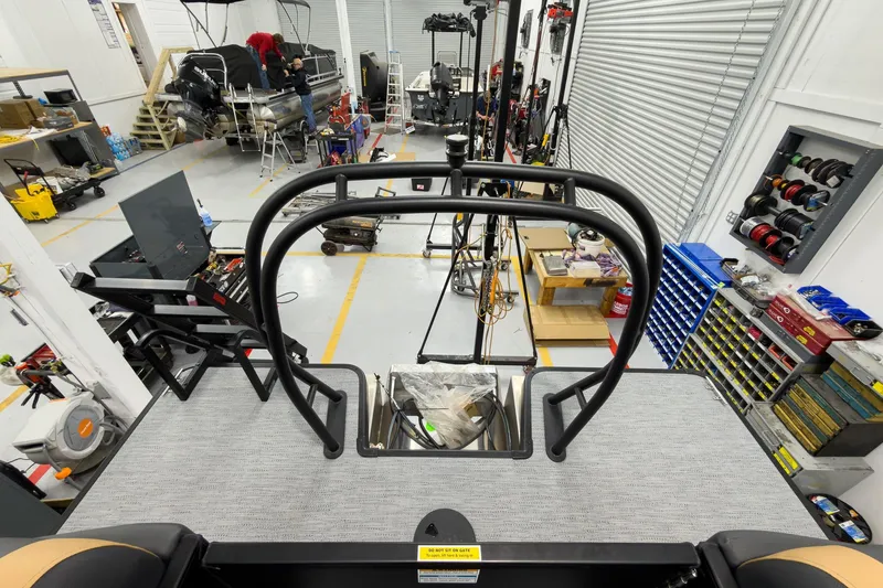 Slide: The Image of Workshop with 2026 Godfrey Sweetwater 22' Tritoon under maintenance, surrounded by tools and equipment. - 27