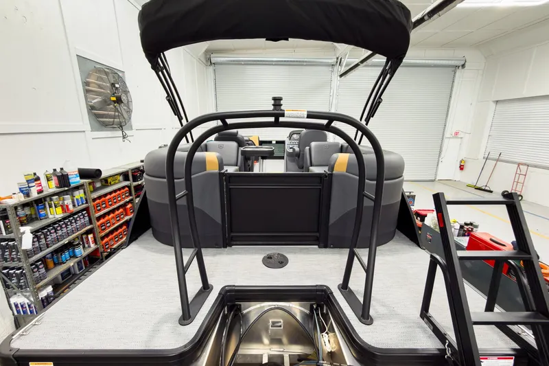 Slide: The Image of 2026 Godfrey Sweetwater 22' Tritoon interior with split bench seating in a showroom. - 6