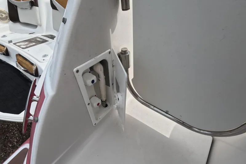 Slide: The Image of 2012 Four Winns V265 boat interior showing a water hookup and seating area. - 24
