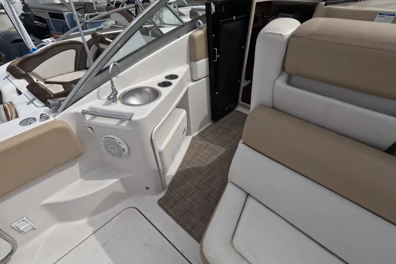 Slide: The Image of 2012 Four Winns V265 boat interior with seating, sink, and storage. - 28