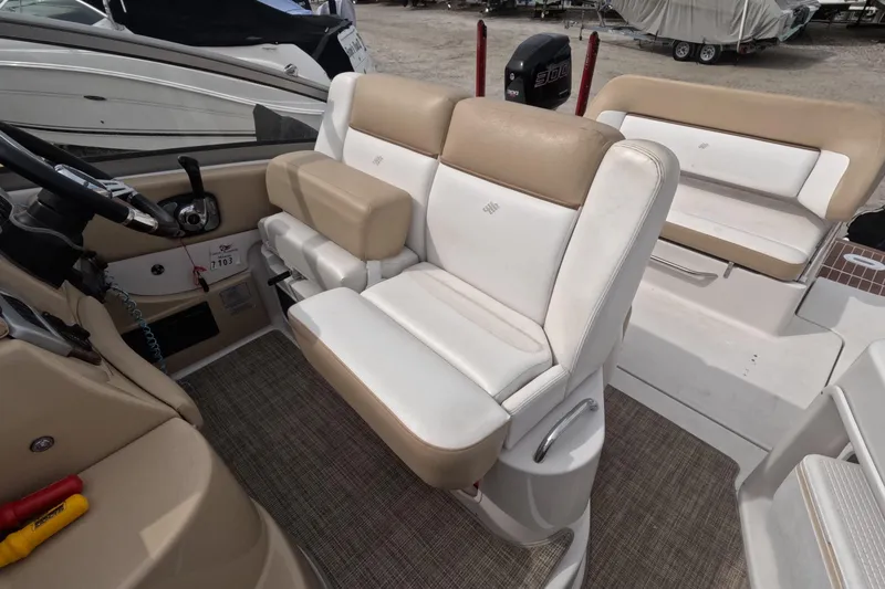 Slide: The Image of 2012 Four Winns V265 boat interior with beige and white seating, steering wheel, and carpeted floor. - 33