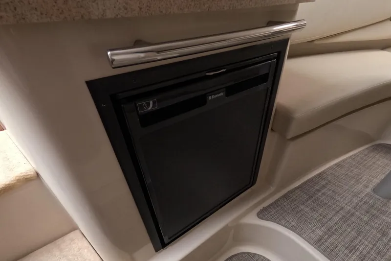 Slide: The Image of 2012 Four Winns V265 boat interior with built-in Dometic refrigerator. - 49