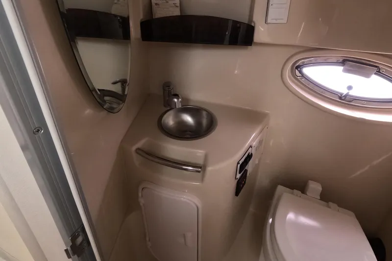 Slide: The Image of 2012 Four Winns V265 boat bathroom with sink, mirror, and porthole window. - 59