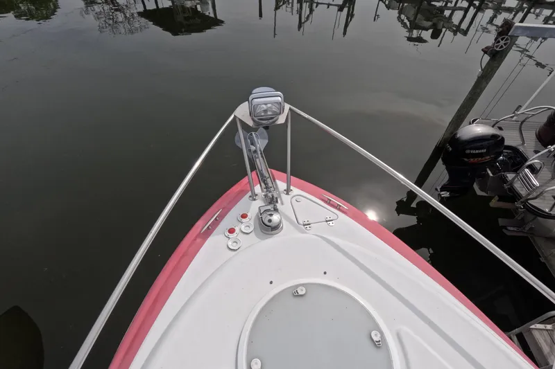 Slide: The Image of Bow view of 2012 Four Winns V265 boat docked on calm water. - 64