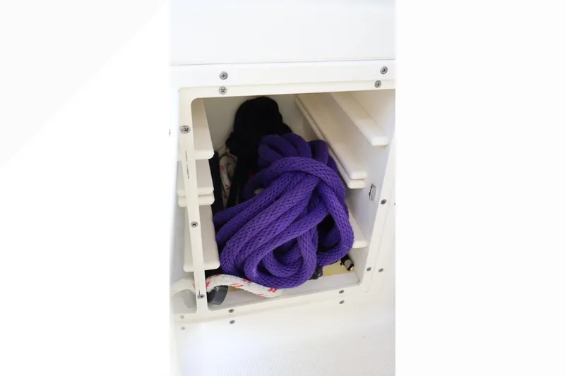 Slide: The Image of Storage compartment with purple rope on a 2006 Pursuit 3070 Offshore boat. - 14