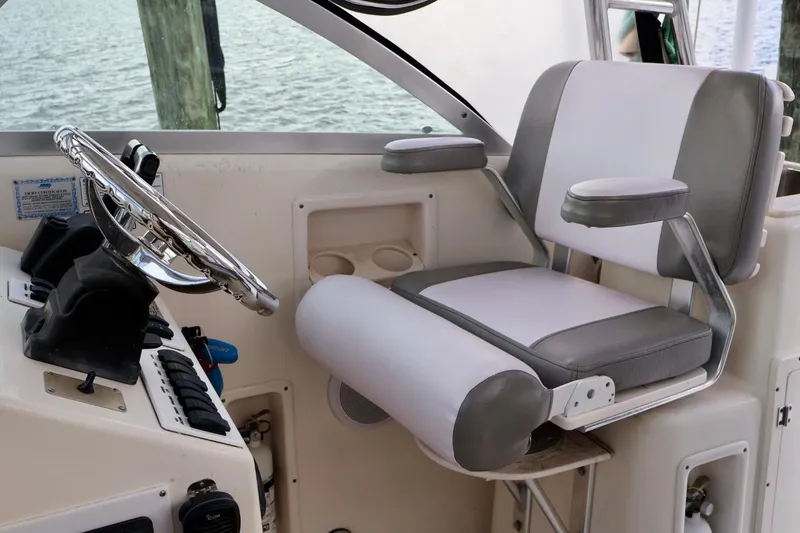 Slide: The Image of Captain's chair and helm of 2006 Pursuit 3070 Offshore boat, featuring sleek design. - 19
