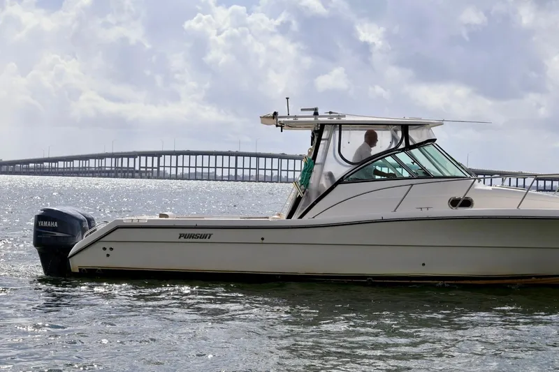 Slide: The Image of 2006 Pursuit 3070 Offshore boat on water with bridge in background. - 3