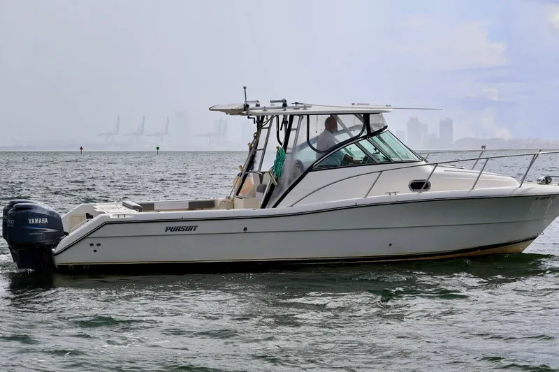 Slide: The Image of 2006 Pursuit 3070 Offshore boat on water with Yamaha engine, city skyline in background. - 5