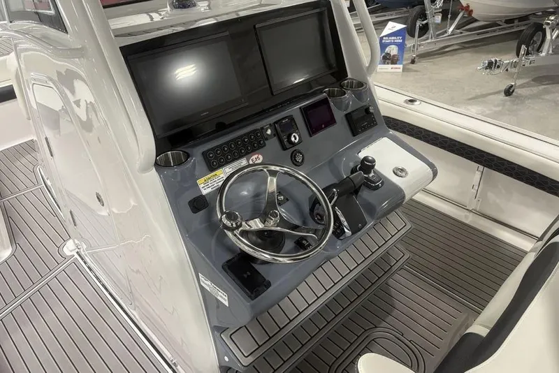 Slide: The Image of 2025 Tidewater 3100 Carolina Bay boat dashboard with modern controls and dual screens. - 22
