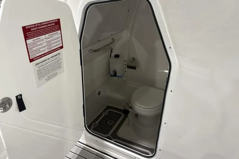 Slide: The Image of 2025 Tidewater 3100 Carolina Bay boat bathroom interior with toilet and safety instructions. - 27