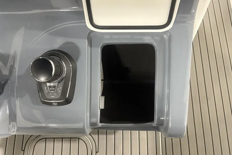Slide: The Image of 2025 Tidewater 3100 Carolina Bay boat control panel with joystick and storage compartment. - 30