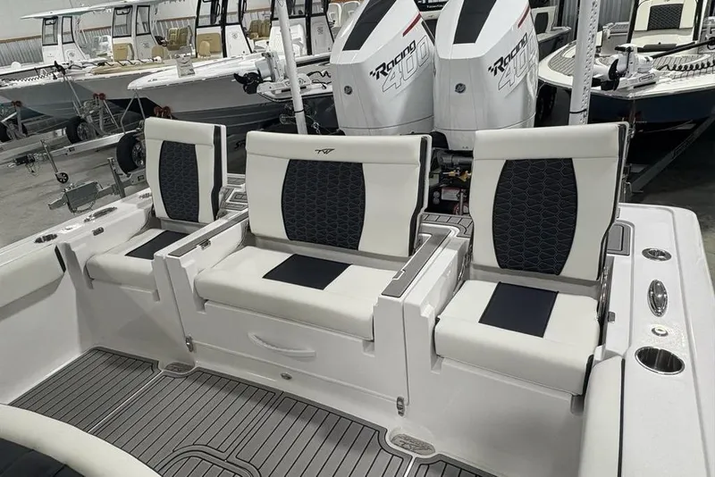Slide: The Image of 2025 Tidewater 3100 Carolina Bay boat interior with three cushioned seats and dual outboard motors. - 45