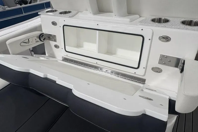 Slide: The Image of 2025 Tidewater 3100 Carolina Bay boat interior with storage compartment and cup holders. - 46